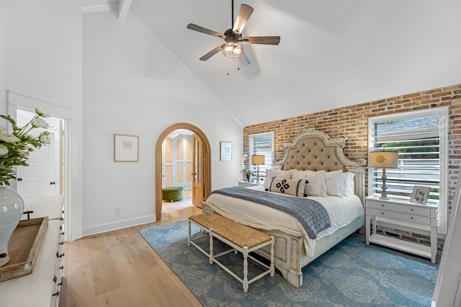 Bright bedroom with an exposed brick wall and arched doorway