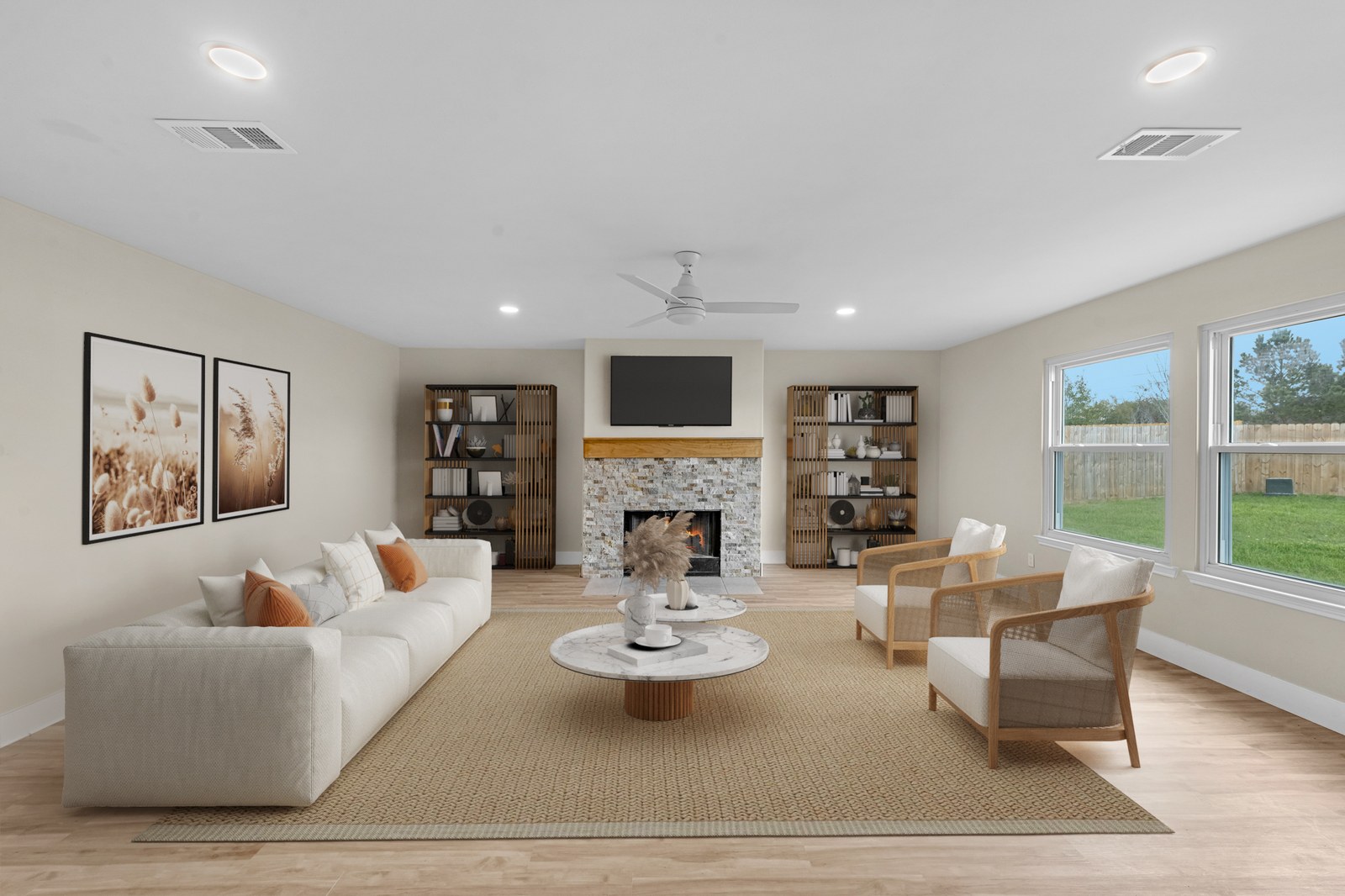 Virtually staged living room with a white sofa, rattan chairs and a stone fireplace