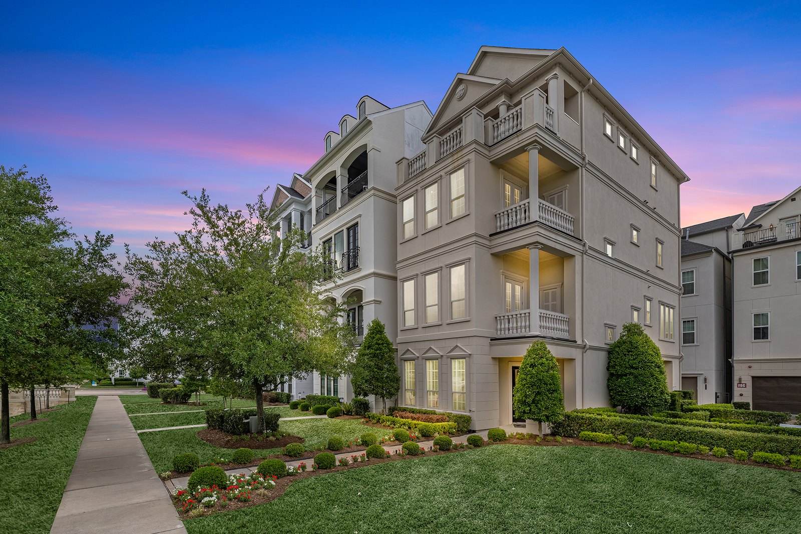 Virtual twilight of a multi-story residence under a pink dusk sky