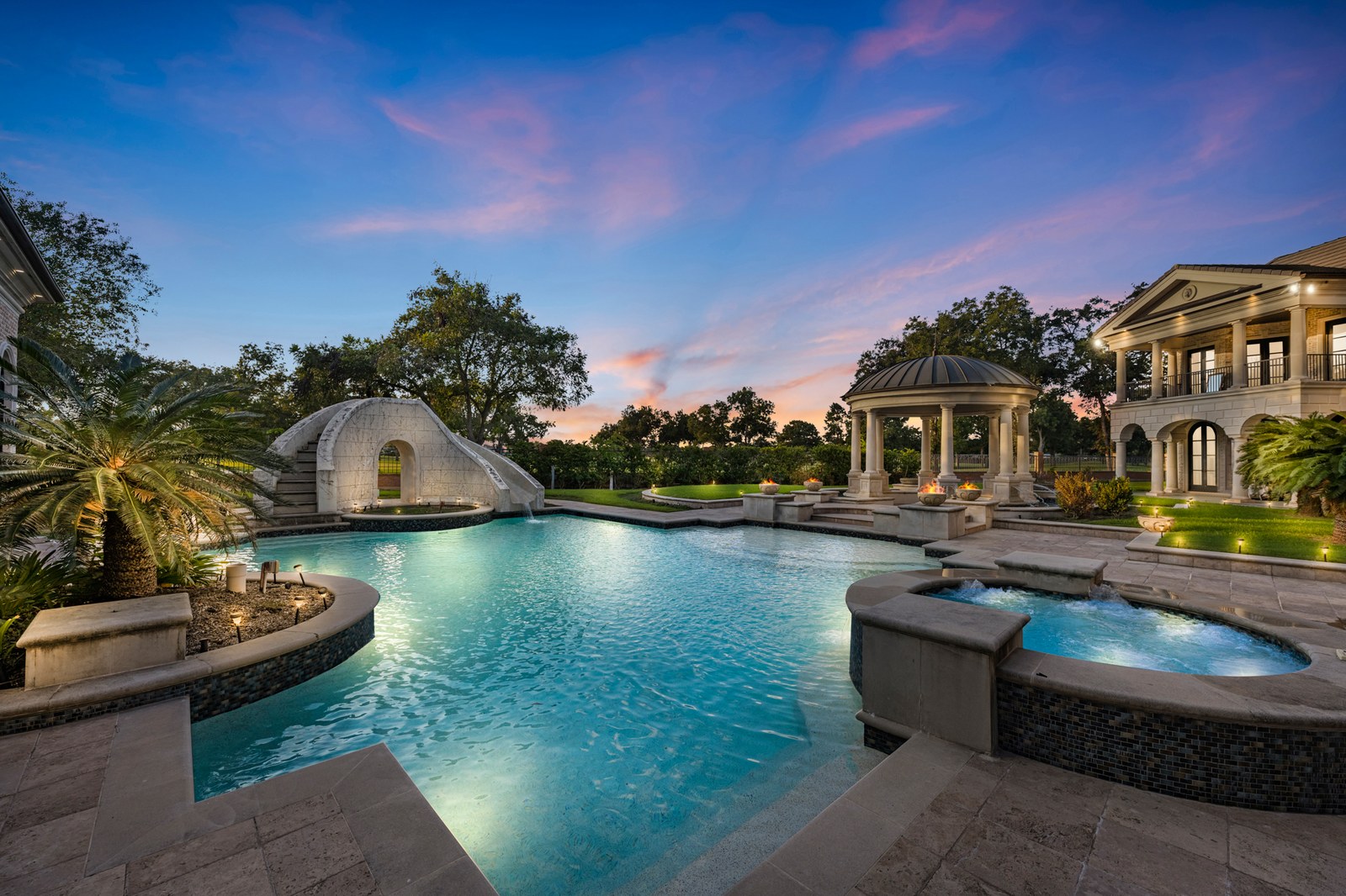 Virtual twilight of a resort-style pool with a grotto slide and gazebo