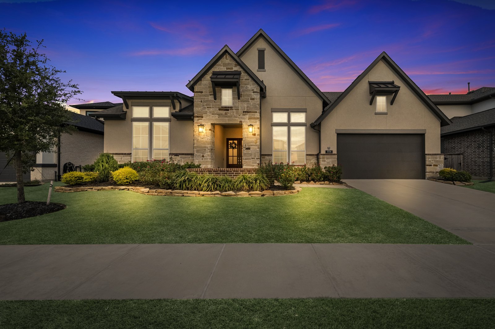 Virtual twilight of a stone-front home under a dramatic dusk sky
