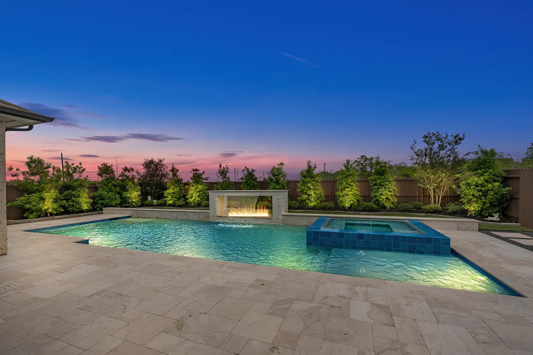 Virtual twilight of a backyard pool with lit fire features